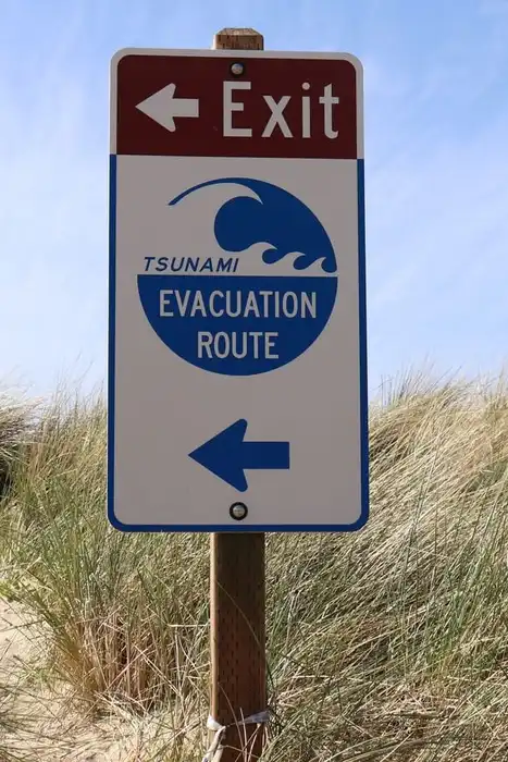 A tsunami evacuation route sign beside a coastal path in Oregon.