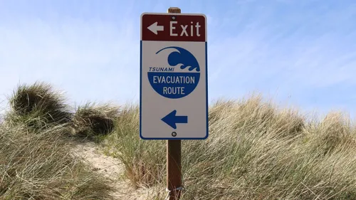 A tsunami evacuation route sign beside a coastal path in Oregon.