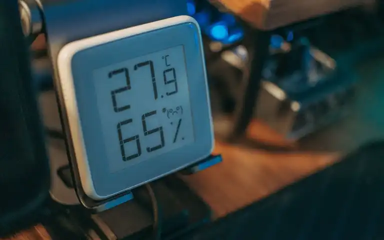 A digital hygrometer displays indoor temperature and relative humidity.
