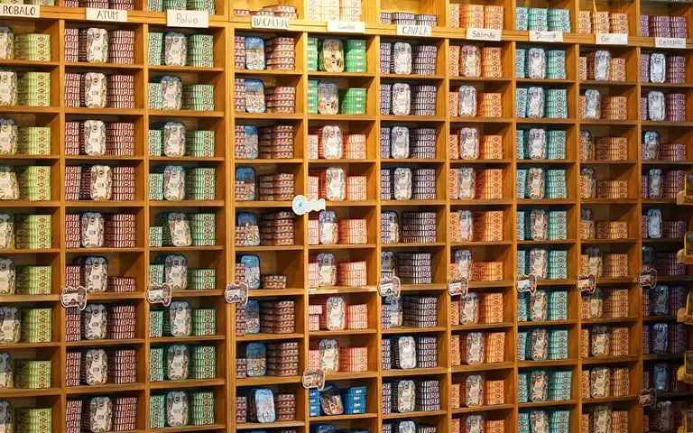 Assorted canned goods are arranged on store shelves.