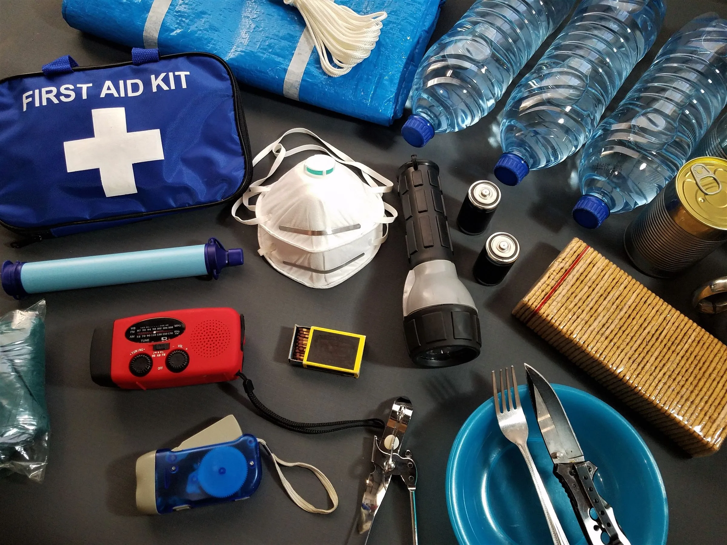A first-aid kit and emergency supplies arranged together.