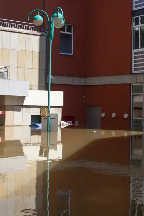 Floodwater standing between residential buildings on an urban street