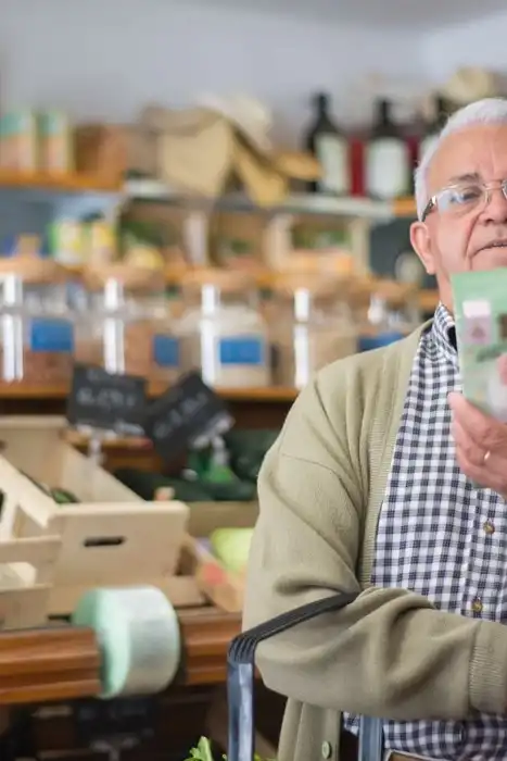 Older shopper looking at a packaged grocery product.