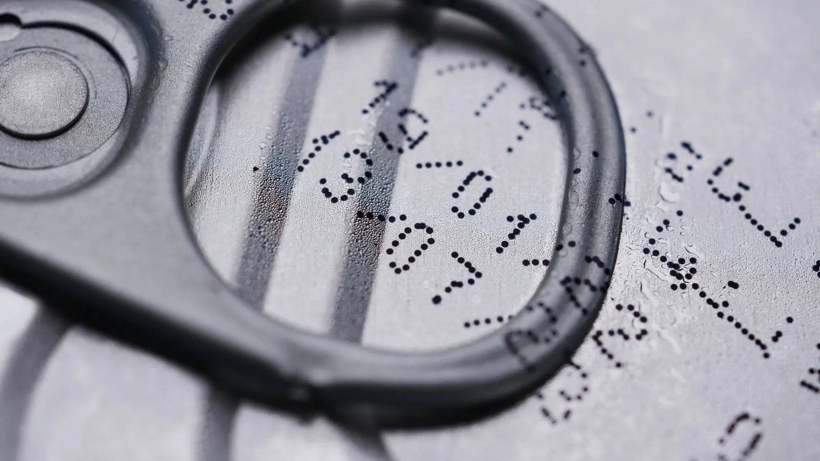 Close-up of a drink-can lid with a printed expiration date.