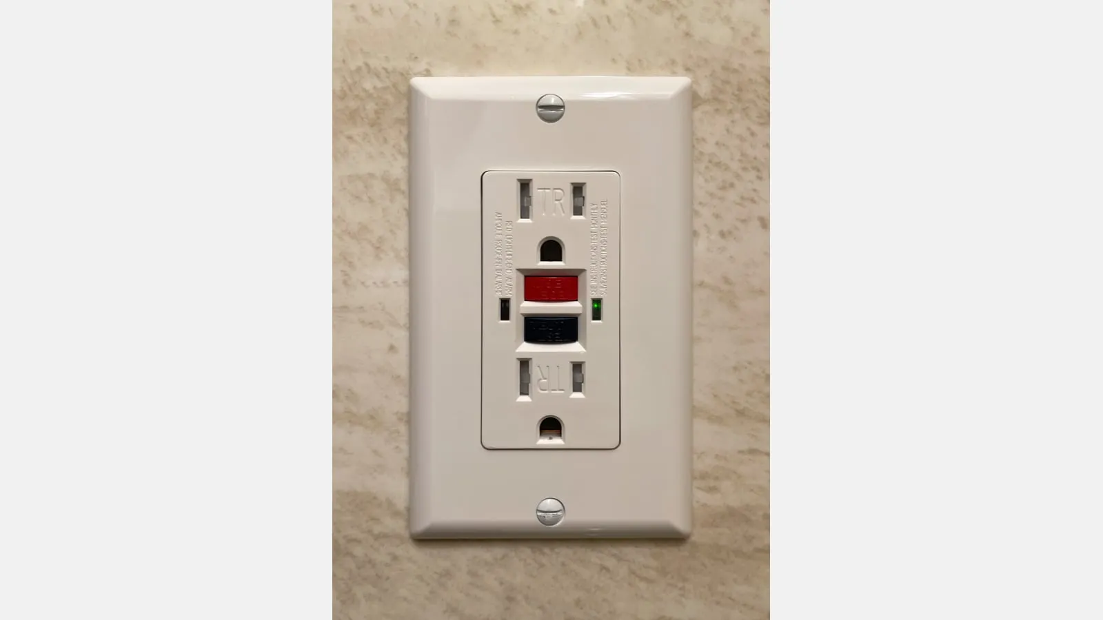 A white North American GFCI receptacle with red reset and black test buttons.