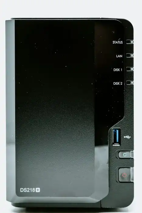 A black two-bay network-attached storage enclosure with status lights and front controls.