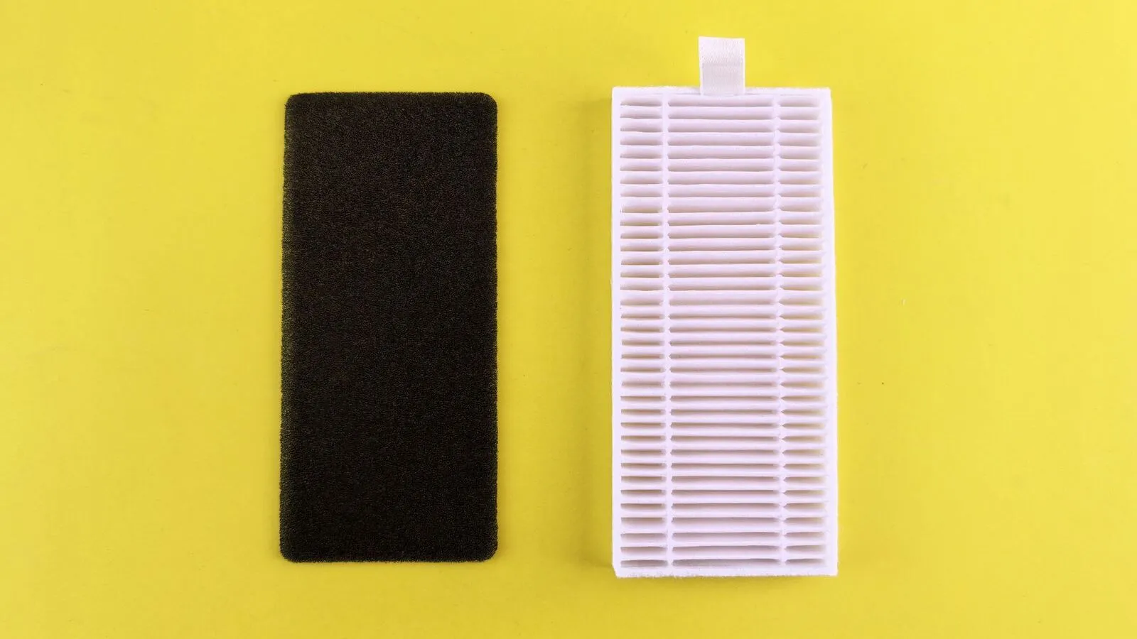 A black foam filter and a white pleated filter are shown against a yellow background.