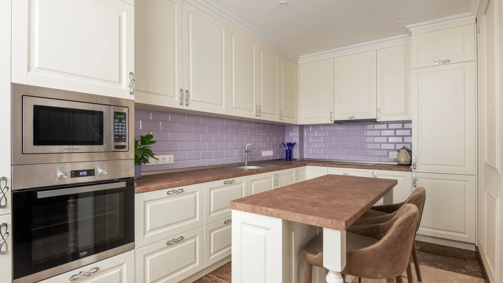 A built-in microwave above an oven in a white kitchen.
