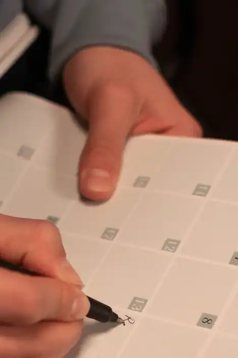 A person writing notes in an open planner.