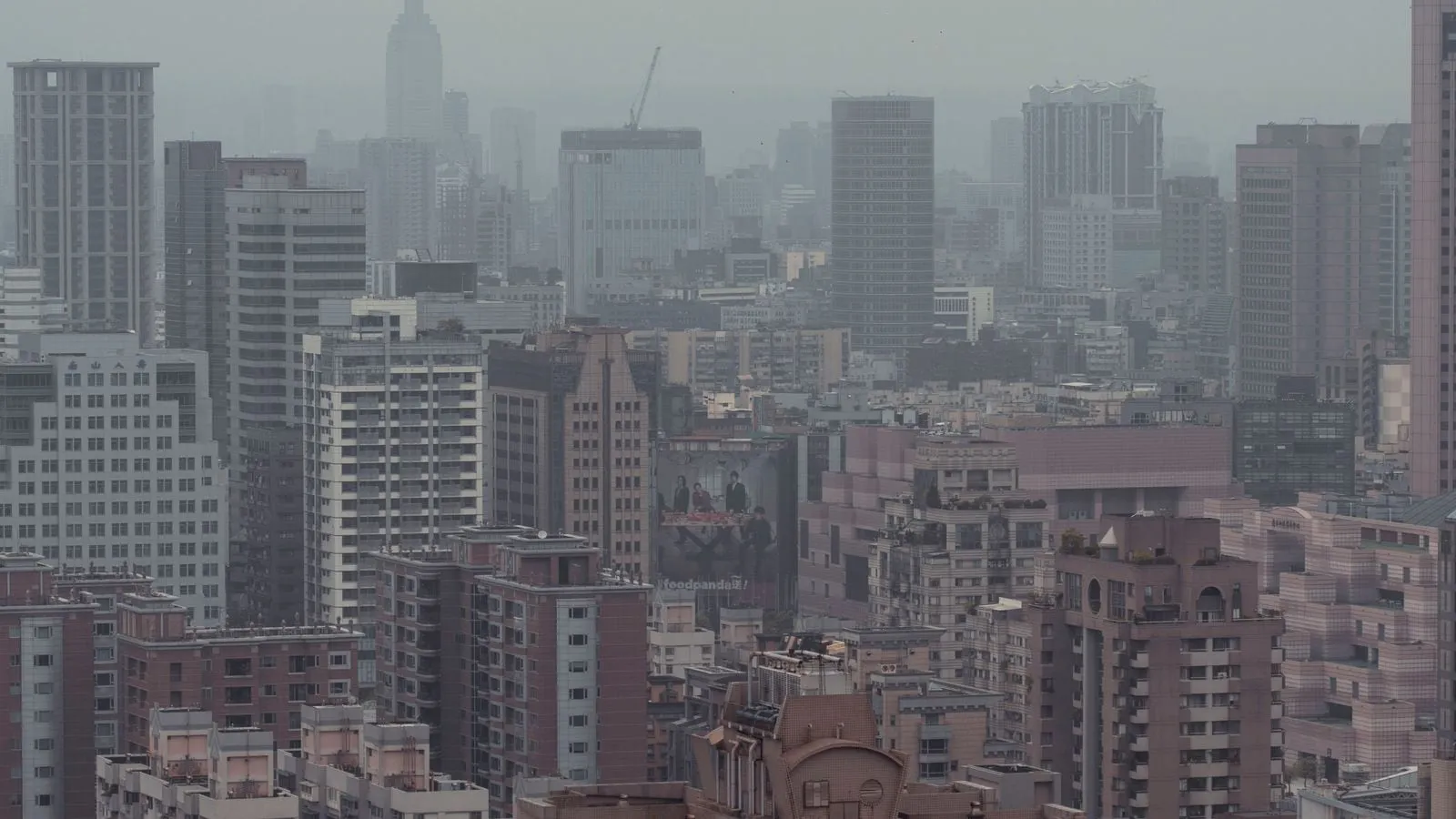 A hazy urban skyline with tall buildings in the distance.