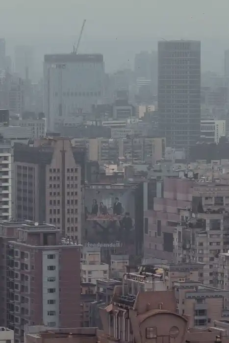A hazy urban skyline with tall buildings in the distance.