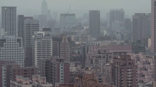A hazy urban skyline with tall buildings in the distance.