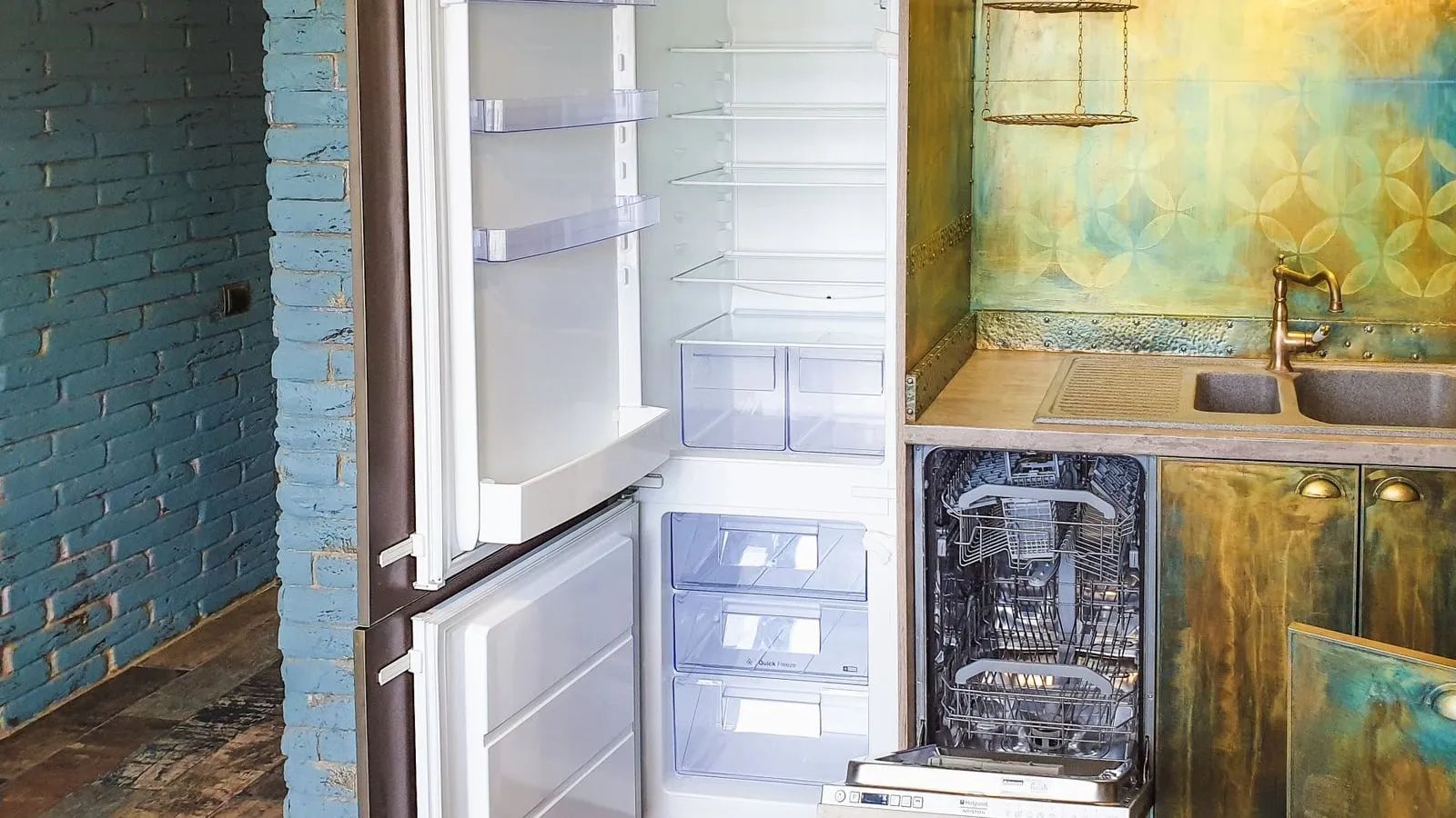 Open refrigerator and dishwasher beside a kitchen sink.