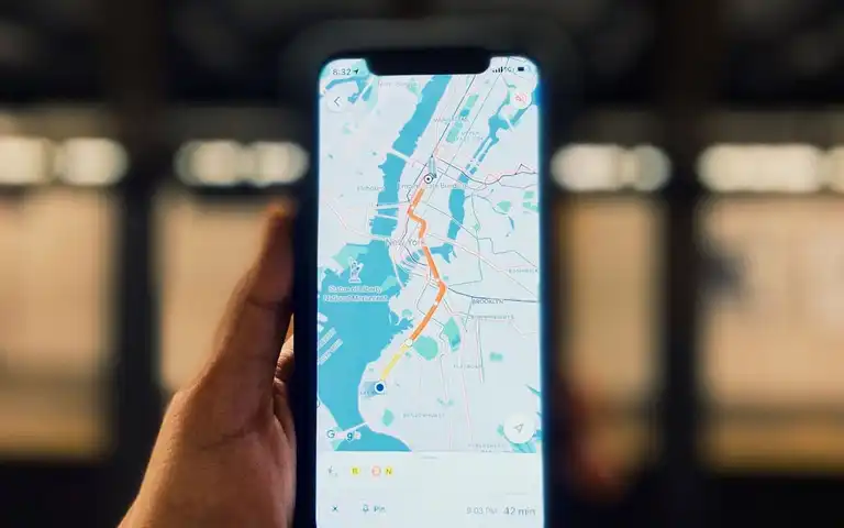A person holding a smartphone that displays a city map.