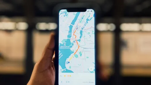 A person holding a smartphone that displays a city map.